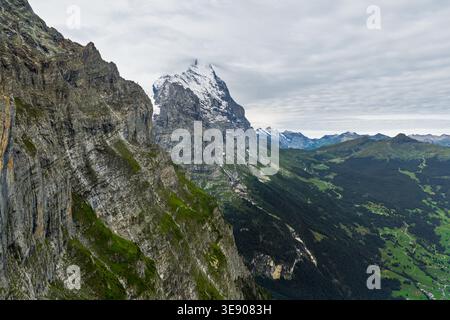 Drohnenansicht der Eiger-Nordwand, die sich über dem Grindelwald erhebt, Berner Oberland, Schweizer Alpen, Schweiz, mit schneebedecktem Gipfel. Stockfoto