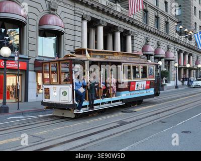 San Francisco, Vereinigte Staaten - 3. Oktober 2025 - Eine historische Seilbahn Powell and Hyde voller Touristen bestiegen eine steile Straße in der Innenstadt von San Franc Stockfoto