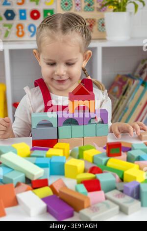 Kind spielt mit bunten Holzblöcken, Blick von oben Stockfoto