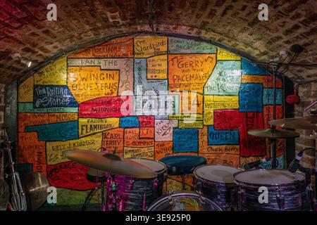 Die ikonische Bühne und die unverkennbare handgemalte Ziegelwand im Cavern Club in der Mathew Street, Liverpool, England. Stockfoto