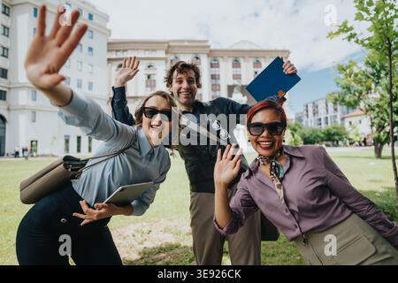 Geschäftskollegen winken und lächeln im Freien vor dem Bürogebäude zusammen Stockfoto