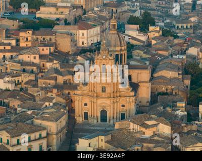 Blick aus der Vogelperspektive auf den Dom von San Giorgio und die historischen Steindächer von Ragusa Ibla während der goldenen Stunde in Ragusa, Sizilien, Italien. Stockfoto