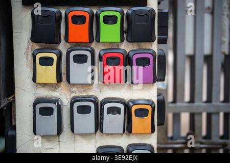 Farbenfrohe Plastikkästen mit Schlüsseln, die spezielle Codes von Mietwohnungen enthalten, die an der Wand angeordnet sind. Stockfoto