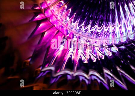 Lebendiges magentafarbenes und violettes abstraktes Lichtmuster, das in einer komplexen kristallinen Glasstruktur reflektiert wird Stockfoto