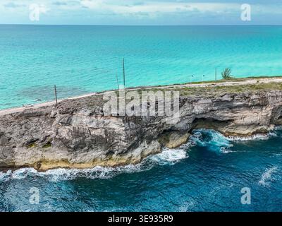 Aus der Vogelperspektive die Glass Window Bridge zeigt die schmale Straße auf zerklüfteten felsigen Klippen zwischen türkisfarbenem und tiefblauem Wasser in Nord-Eleuthera, Norden Stockfoto