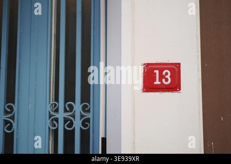 Nummer 13 in einem Gebäude mit blauen Türen in einer Stadt Stockfoto