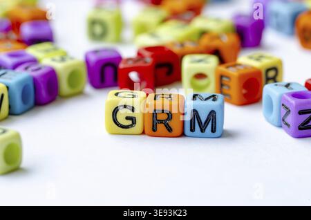 GRM-Text auf mehrfarbigen Würfeln, die den Beschwerdemechanismus darstellen. Erhaltungskonzept Stockfoto
