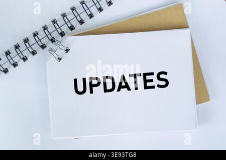 Ansicht oben des Textes „Updates“ auf weißem Notizblock. Business Update-Konzept Stockfoto