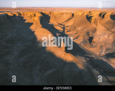 Aus der Vogelperspektive der dramatischen Badlands und erodierten Felsformationen, die während des Sonnenuntergangs in Hanksville, Utah, USA, lange Schatten werfen. Stockfoto