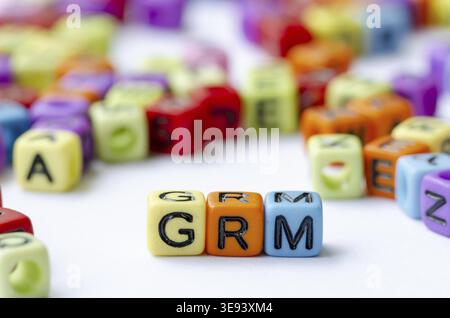 Nahaufnahme des GRM-Textes auf mehrfarbigen Würfeln, die den Beschwerdemechanismus darstellen. Erhaltungskonzept Stockfoto