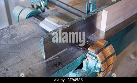 Holzblock bewegt sich auf einer Hobelmaschine Stockfoto