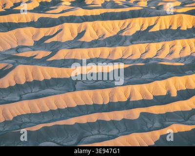 Aus der Vogelperspektive auf die komplexen erodierten Grate und Badlands am Fuße des Factory Butte während der goldenen Stunde im Wayne County, Utah, USA. Stockfoto