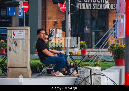 Mann und Frau ruhen sich mit eisgekühlten Getränken in einem Open-Air-Restaurant aus Stockfoto