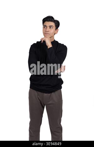 Nachdenklicher junger Mann, der Hand am Kinn hält und denkt Stockfoto