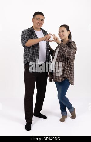 Paare in karierten Hemden, die mit den Händen eine Herzgeste machen Stockfoto