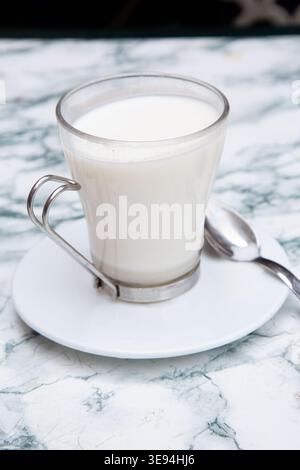 Milchglasszene. Minimalistisches Küchen-Stillleben Mit Milchglas Und Löffel Mit Weichem Tageslicht Stockfoto