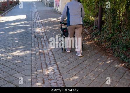 Rentner mit Rollatoren und gehen auf dem Bürgersteig Stockfoto