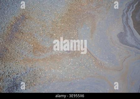 Ölfleck auf einem Asphalt in einer Pfütze der Umweltverschmutzung Stockfoto