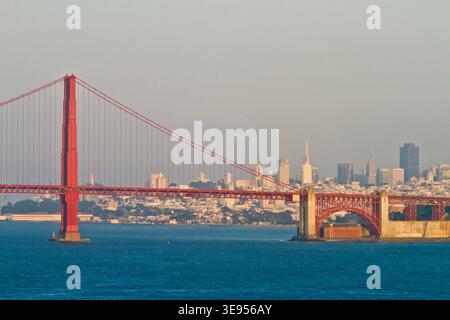 Die Golden Gate Bridge überspannt die Bucht mit ihren roten Türmen und Kabeln vor einem trüben Himmel. Stockfoto