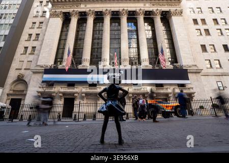 Eine Bronzestatue einer Frau steht selbstbewusst vor einem großen klassischen Gebäude mit hohen Säulen und amerikanischen Flaggen. Stockfoto