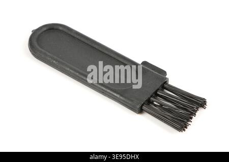 Kleine schwarze Kunststoff-Reinigungsbürste isoliert auf weißem Hintergrund. Zubehör zum Reinigen von Elektrorasierern oder Fusselentfernern. Stockfoto