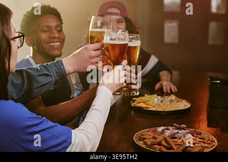In der Kampagne „Pub for Social Gathering“ stoßen verschiedene Freunde Bier an Stockfoto
