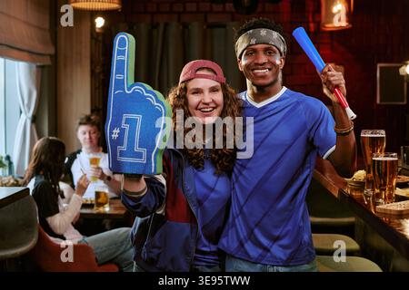 Porträt verschiedener erwachsener Sportfans, die im Pub for Team anfeuern Stockfoto