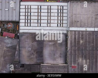 Luftaufnahme von Industriedächern mit verwitterten Texturen und geometrischen Mustern in Leccio, Toskana, Italien. Stockfoto
