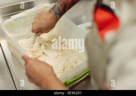 Nahaufnahme des fermentierten Teigs in der Schüssel Weißmehl Gärungshefe gesäuertes Brot Backen Biga poolish Bäckerei Stockfoto