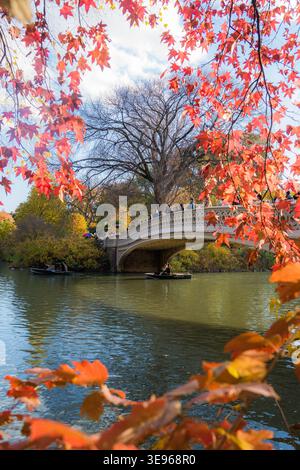 Manhattan, Vereinigte Staaten - 08. November 2025: Blick auf die Bow Bridge im Central Park, eingerahmt vom lebhaften Herbstlaub und reflektiert auf dem ruhigen See Stockfoto