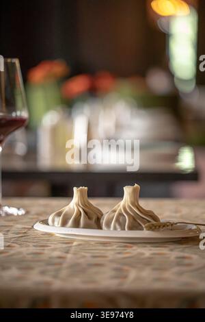 Khinkali-Teigtaschen mit Wein auf dem Restauranttisch Stockfoto