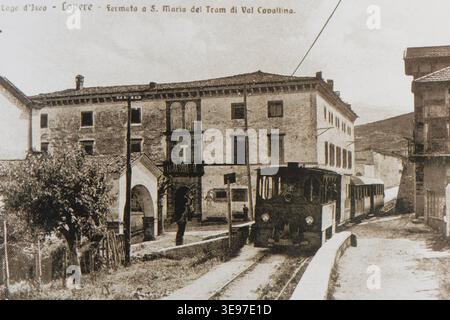 Die Straßenbahn der Bahnstrecke Val Cavallina, Linie Trescore-Lovere, wird vor 1915 an der Haltestelle Lovere Santa Maria gezeigt. Der historische Fotodruck dokumentiert das Straßenbahnfahrzeug und die Transportinfrastruktur des frühen 20. Jahrhunderts in Italien. Stockfoto