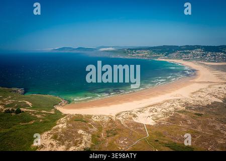 Blick Aus Der Vogelperspektive Auf Den Sandstrand Und Die Geschwungene Küste Mit Dünen Und Küstenstadt Am Klaren Tag, Valdovino Beach, Galicien, Spanien Stockfoto