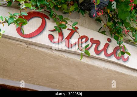 Typisches talianisches Osteria-Schild (in englischer Taverne), gemalt auf einer Steinmauer am Eingang eines gemütlichen Restaurants in Pienza, Toskana Stockfoto