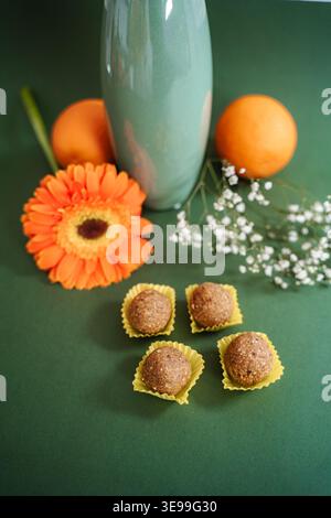 Energiebälle mit orangener Gerbera-Blume und grüner Vase Stockfoto