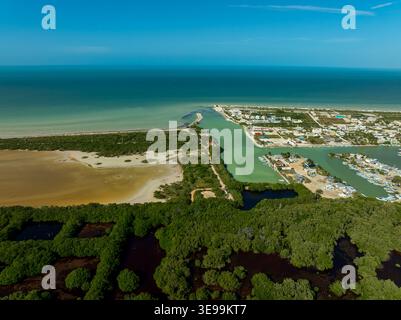 Aus der Vogelperspektive auf die lebhaften grünen Mangroven und eine ruhige türkisfarbene Lagune, die auf das klare blaue Meer in Sisal, Yucatan, Mexiko trifft. Stockfoto