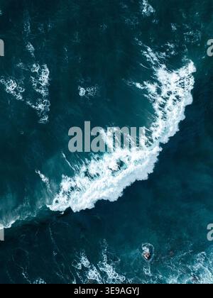 Luftaufnahme einer mächtigen brechenden Welle mit weißem Schaum und tiefblauem Wasser Madeira, Portugal. Stockfoto