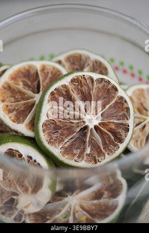 Getrocknete Limettenscheiben in einer Glasschale auf einem Tisch Stockfoto