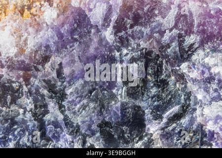 Das irisierende violette Mineralfeld erinnert an dunkle Höhlen und Silberflecken, den Eindruck kosmischer Nebel, surreale abstrakte Oberfläche für futuristische Komposition Stockfoto