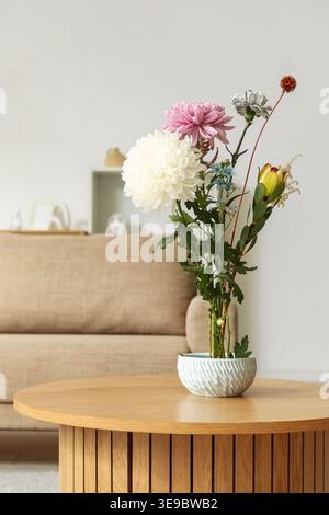 Topf mit wunderschönem Ikebana auf Couchtisch in stilvollem Wohnzimmer, Nahaufnahme Stockfoto