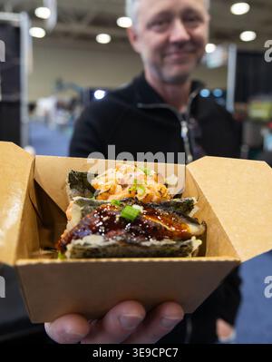 Toronto, Kanada. April 2026. Ein Mann zeigt Sushi-Tacos beim T.O. Food & Drink fest in Toronto, Kanada, 17. April 2026. Die dreitägige jährliche Veranstaltung mit über 150 Ausstellern begann hier am Freitag mit einer großen Auswahl an Speisen und Getränken. Quelle: Zou Zheng/Xinhua/Alamy Live News Stockfoto