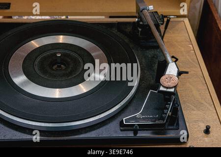 Ein Vintage-Plattenspieler der Serie Garrard SP25 MK III aus den 1970er Jahren mit einer britischen zwei-Pence-Münze, die auf der Kopfschale platziert ist, um die Verfolgung zu verbessern Stockfoto