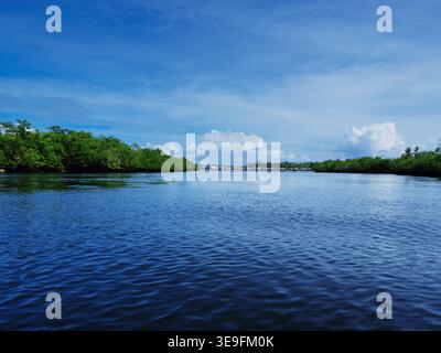 POV vom Bug des blauen Auslegers bangka, der sich dem Küstendorf Siargao auf den Philippinen nähert Stockfoto