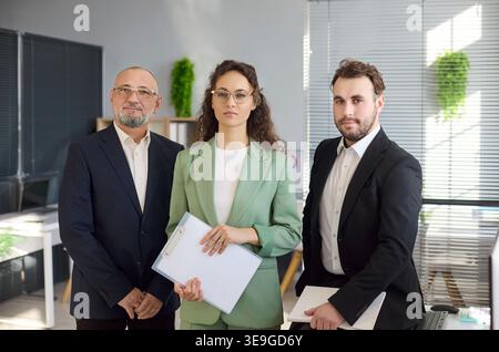 Porträt des Geschäftsteams von drei selbstbewussten Profis in einem modernen Büro Stockfoto