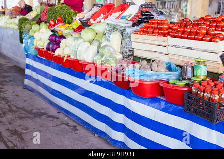Frisches Gemüse am Marktstand. Rote Tomaten in Holzkisten, Grünkohl, Paprika in Gläsern, produzieren reichlich, gesunde Bio-Ernte Stockfoto