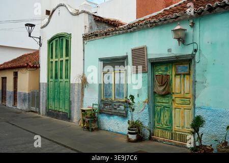 Charmante alte Straße mit farbenfrohen türkisfarbenen und weißen Häusern. Verwitterte Holztüren und -Fenster zeigen traditionelle kanarische Architektur Stockfoto