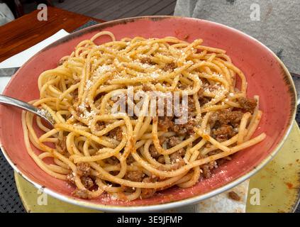 Spaghetti Bolognese in roter Schüssel auf dem Tisch, Konzept des Restaurants, italienische Küche, Food Blog, Copyspace Stockfoto