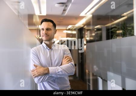 Porträt eines nachdenklichen Geschäftsmannes, der im Bürokorridor steht Stockfoto
