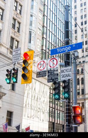 Toronto, Kanada - 17. April 2026: Reflektierende Glashochhäuser und aktive Fußgängersignale markieren das geschäftige Stadtzentrum Stockfoto