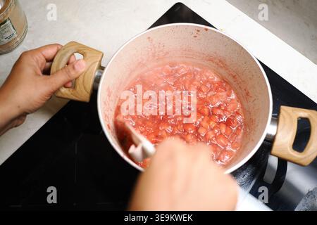 Erdbeermarmelade in einem Topf auf dem Herd kochen Stockfoto
